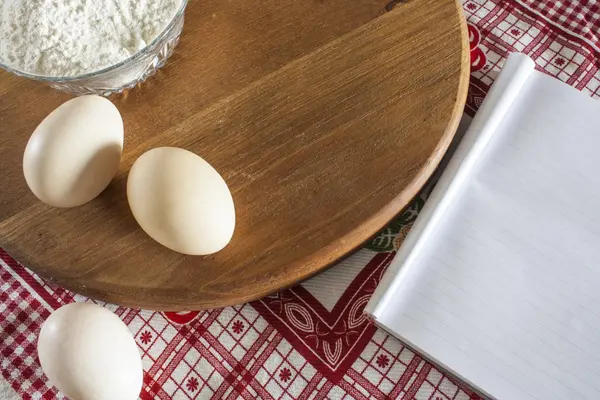Кулінарна композиція. плоть і яйця з порожньою кулінарною книгою та червоним рушником — стокове фото