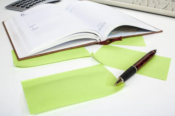 Diário, calculadora, caneta, teclado e notas de papel verde — Fotografia de Stock