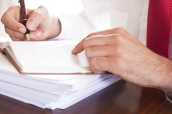 Homme d'affaires écrivant des notes dans la table du bureau — Photo