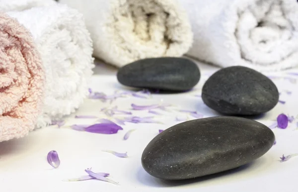 Line of towels with different colours , petals and stones — Stock Photo, Image