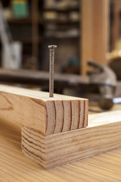 Hamer en nagel in houten tafel bouw achtergrond — Stockfoto