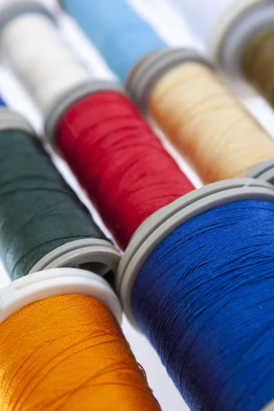 Many different sized colored and shaped thread reels on wood table — Stock Photo, Image