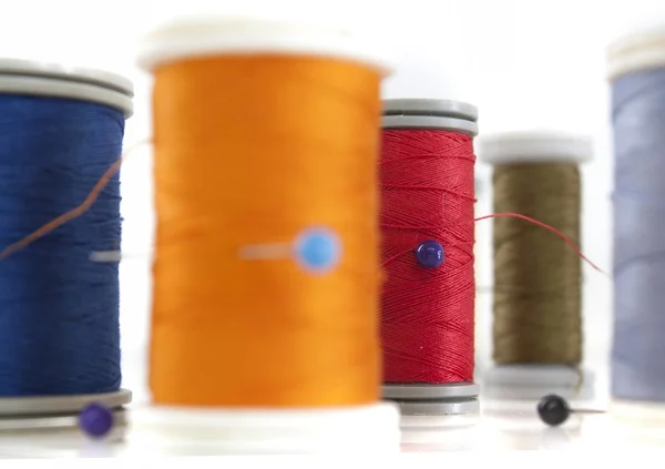 Molteplici bobine di filo colorato e sagomato di dimensioni diverse su sfondo bianco — Foto Stock