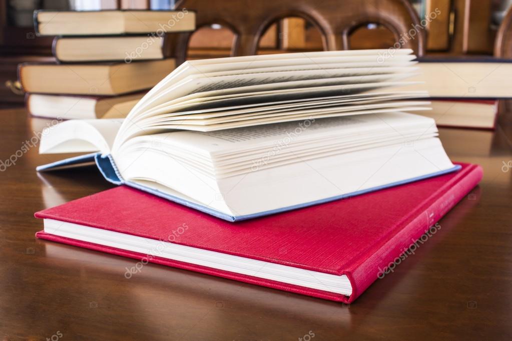 Many different sized colored and shaped books on wood table