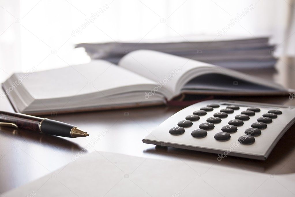 Planner with pen and calculator on the table