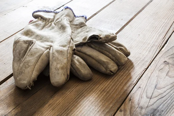 Oude werkhandschoenen over houten tafel — Stockfoto