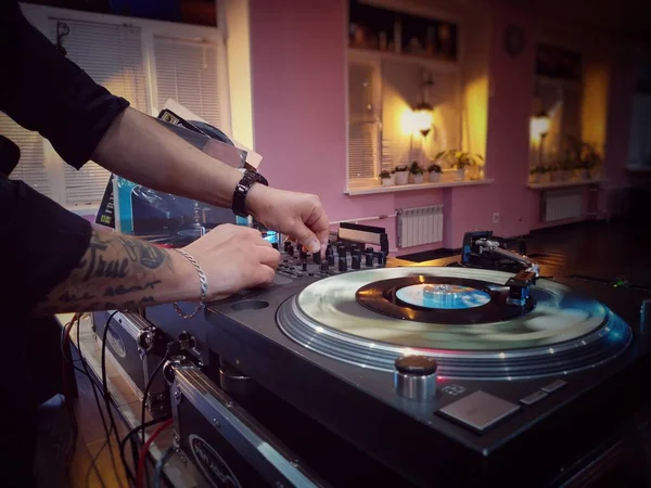 Manos de un DJ poniendo un disco de música en un salón de baile —  Fotos de Stock