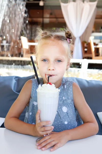 Dziewczynka z lodów mleka wstrząsnąć w kawiarni na świeżym powietrzu — Zdjęcie stockowe