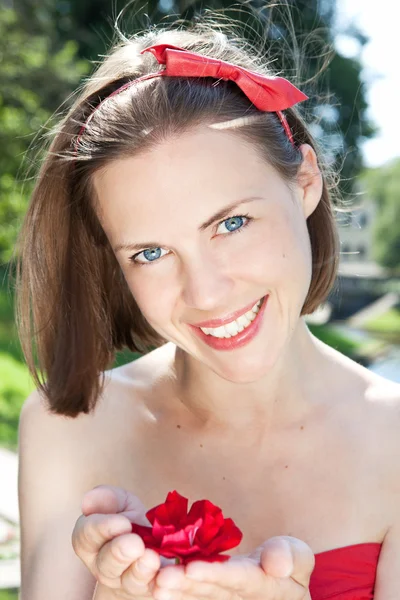 Mujer hermosa sosteniendo flor roja — Foto de Stock