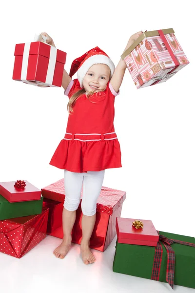 Linda niña en sombrero de ayudante de santa con regalos en blanco — Foto de Stock