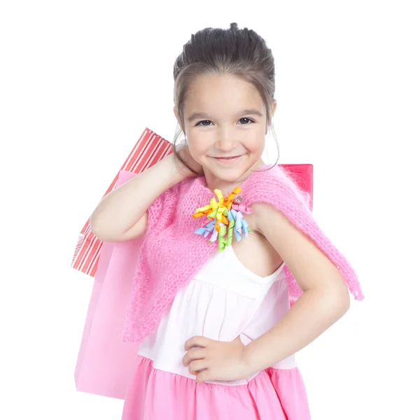 Petite fille souriante avec des sacs à provisions sur blanc — Photo