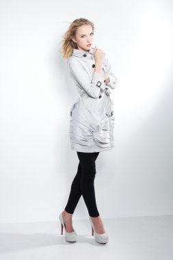 gra üzerinde gri paltolu güzel sarışın moda kız resmi