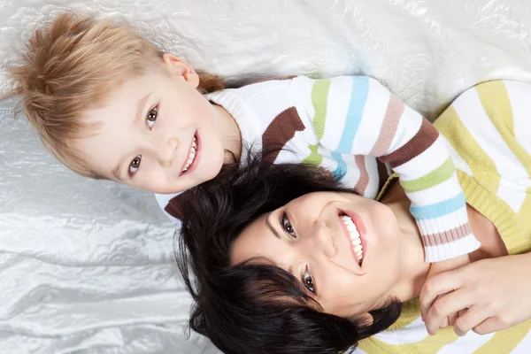 Mutlu anne ile küçük oğlu bir yatakta yatarken — Stok fotoğraf