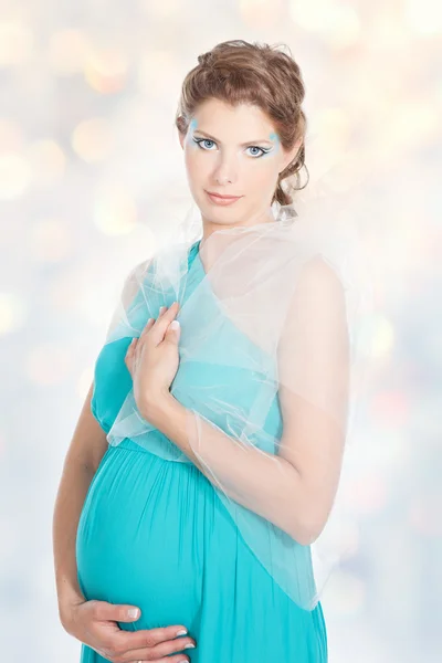 Joven mujer embarazada sonriente en vestido azul — Foto de Stock