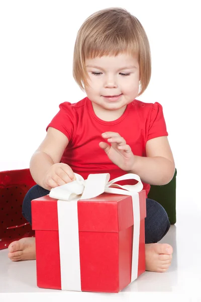 Little girl opening the red gift — Stock Photo, Image