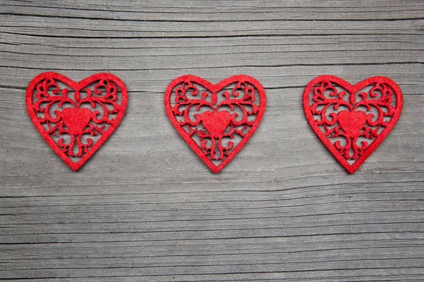 Three hearts on wooden background — Stock Photo, Image