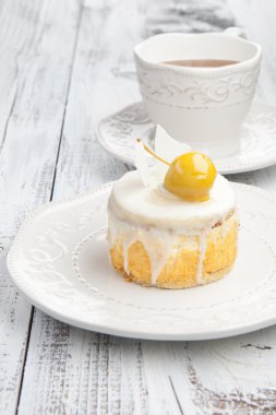 Beyaz ahşap masa üzerinde çay ile tatlı pasta