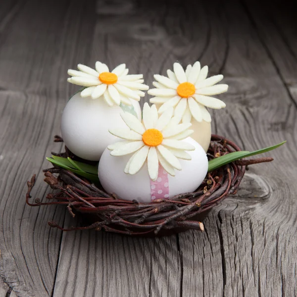 Påskägg och blommor i ett rede — Stockfoto