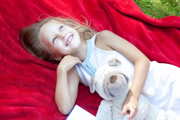 Beautiful little girl relaxing on a meadow — Stock Photo, Image