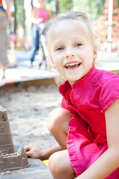 Little girl playing on a sandbox — Stock Photo, Image