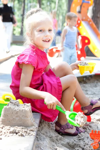 Little girl playing on a sandbox — Stock Photo, Image