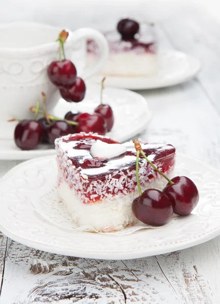 Sweet cakes with cherries on white wooden table — Stock Photo, Image