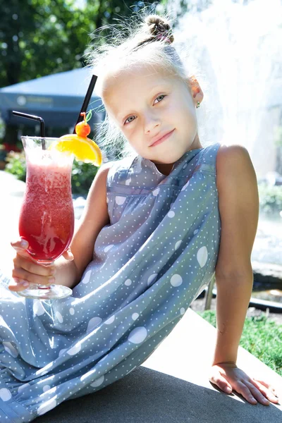 Little girl with fruit cocktail outdoor — Stock Photo, Image