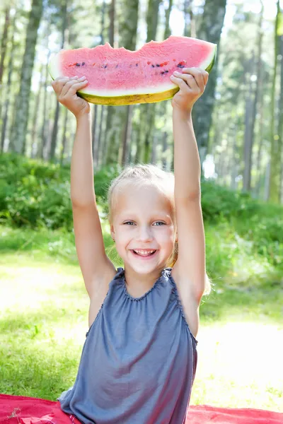 Funny child eating watermelon in the park — Stock fotografie