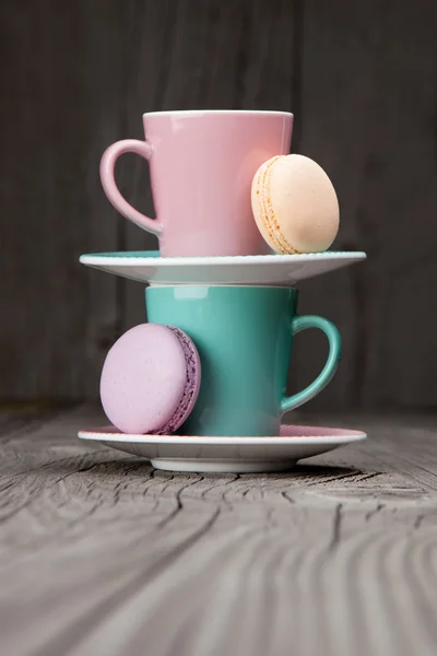 Tazas de café con macarrones franceses sobre mesa de madera — Foto de Stock