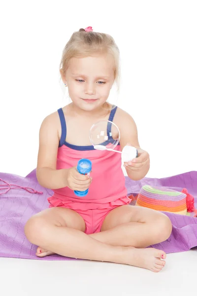 Маленькая девочка с мыльными пузырями на белом — стоковое фото