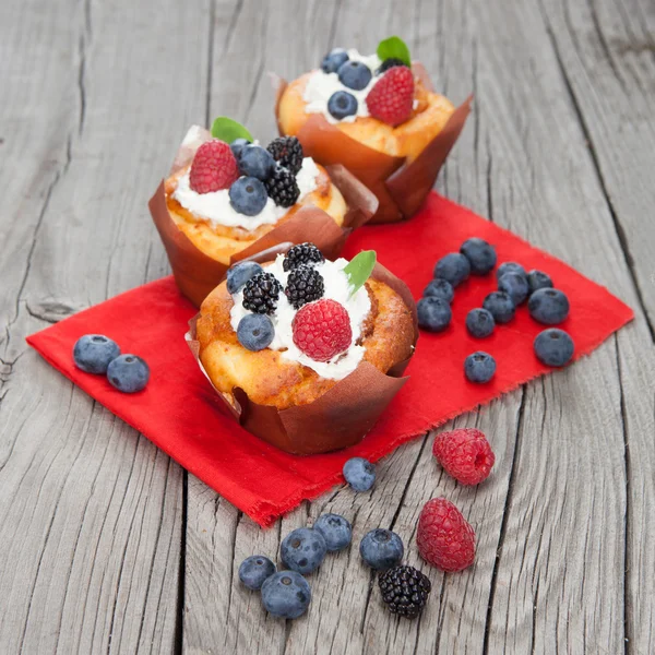 Mumsiga muffins med bär på träbord — Stockfoto