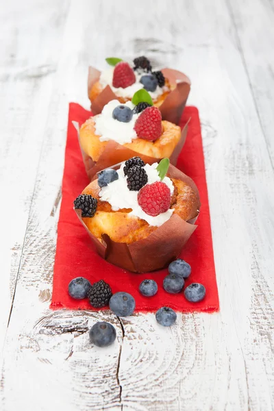 Gâteaux savoureux aux baies sur table en bois blanc — Photo