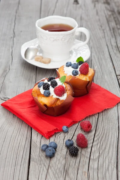 Sabrosos cupcakes con bayas en la mesa de madera — Foto de Stock