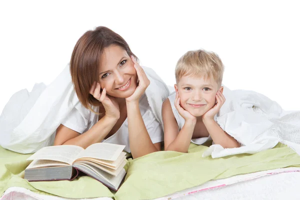 Happy family - mother and son lying on the white bed — Stock Photo, Image