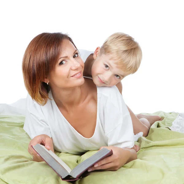 Happy family - mother and son lying on the white bed — Stock Photo, Image