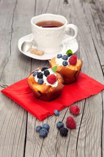 Ahşap masa üzerinde meyveleri ile lezzetli kekler — Stok fotoğraf