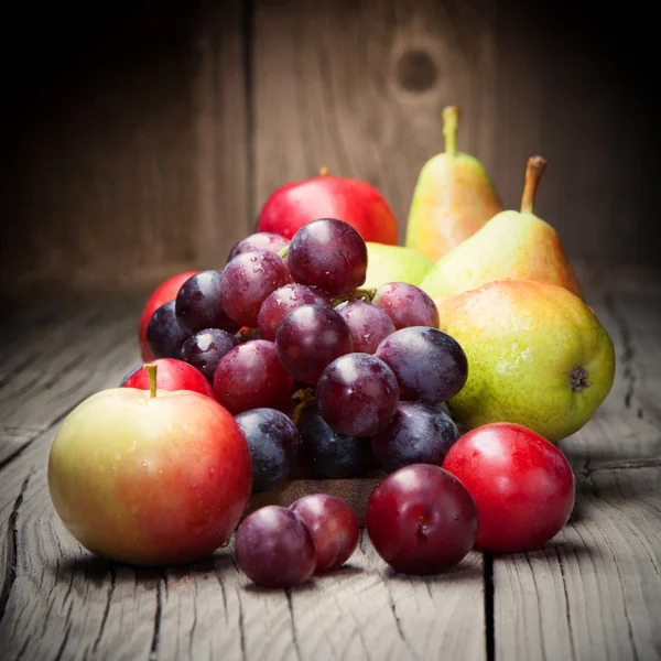 Harvested grapes, apples, ripe pears and plums — Stock Photo, Image