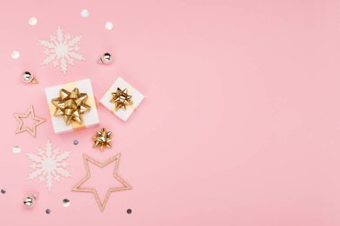 Noel tebrik kartı şablonu. Altın ve gümüş madalyalar, şenlikli hediyeler, pembe arka planda kar taneleri. Xmas, kış, yeni yıl konsepti. Düz konum, üst görünüm, kopyalama alanı.