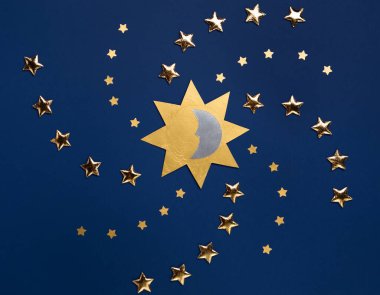 Kış gündönümü tatili, 21 Aralık. Yılın en uzun gecesi konsepti. Koyu mavi kağıtta güneş, ay ve altın yıldızların sembolü. Düz konum, üst görünüm, kopyalama alanı. 