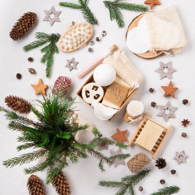 Sıfır atık çevre dostu Noel tatili konsepti. Şenlikli kış bakım paketi. Beyaz doğal zemin üzerinde plastiksiz kozmetik ürünleri olan hediye kutusu, üst görünüm, boşluk kopyala.