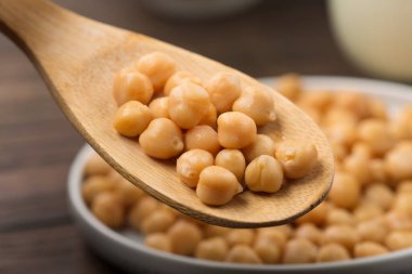 Koyu ahşap arka planda nohut pişirdim. Seçici odak, uzayı kopyala. Sağlıklı, besleyici, glütensiz ve vejetaryen gıda konsepti.