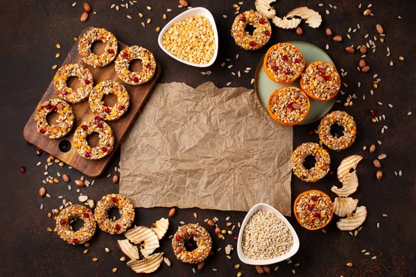 Homemade birdseed dumplings, winter food for birds on dark wooden background, top view. Dried grains bird food, sunflower seeds - energy bird fat balls.