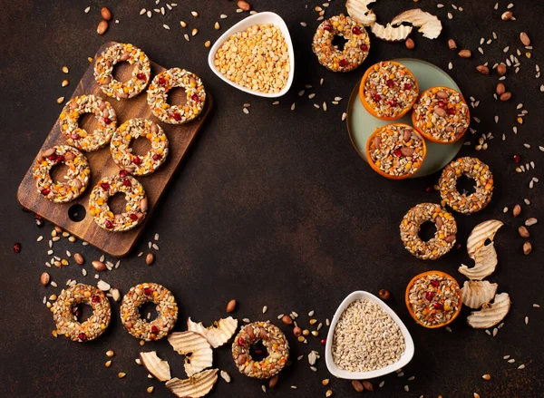 Homemade birdseed dumplings, winter food for birds on dark wooden background, top view, copy space. Dried grains bird food, sunflower seeds - energy bird fat balls.