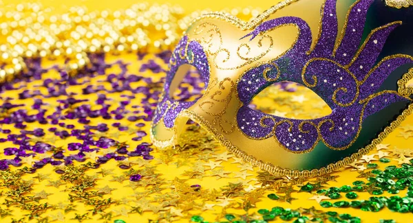 狂欢节的狂欢节面具 金黄色的珠子和黄色背景的金色 紫色的领带 宴会请柬 过冬狂欢节的概念 — 图库照片