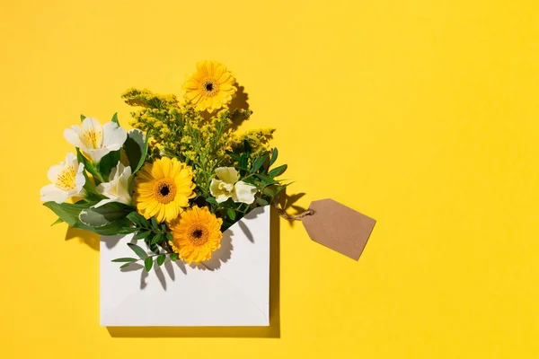 お祭りの休日の花の組成 紙の上に黄色と白の花黄色の背景 イースターカードのコンセプト フラットレイアウト トップビュー コピースペース — ストック写真