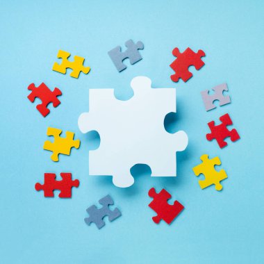 Dünya Otizm Bilinci Günü ya da ay konsepti. 2 Nisan için yaratıcı tasarım. Renk bulmacası, mavi arka planda otizm spektrum bozukluğuna dair farkındalığın sembolü. Üst görünüm, metin için boşluk kopyala. 