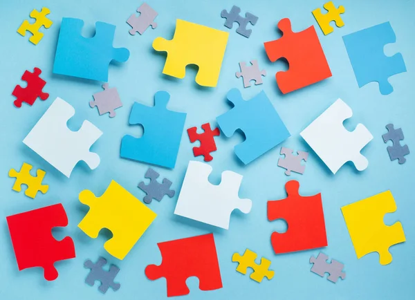 Dünya Otizm Bilinci Günü ya da ay konsepti. 2 Nisan için yaratıcı tasarım. Renk bulmacası, mavi arka planda otizm spektrum bozukluğuna dair farkındalığın sembolü. Üst görünüm, metin için boşluk kopyala. 