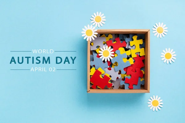 世界自動認識の日または月の概念 4月2日のクリエイティブデザイン 色のパズル 青の背景に自閉症スペクトラム障害とデイジーの花のための意識のシンボル トップビュー コピースペース — ストック写真