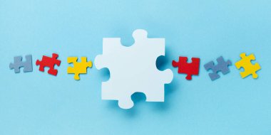 Dünya Otizm Bilinci Günü ya da ay konsepti. 2 Nisan için yaratıcı tasarım. Renk bulmacası, mavi arka planda otizm spektrum bozukluğuna dair farkındalığın sembolü. Üst görünüm, alanı kopyala.