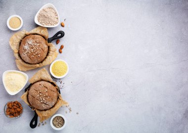 Gluten Free Homemade Bread. Healthy eating, dieting, balanced food concept. Cereals gluten-free, millet, quinoa, almond, buckwheat, flax seeds, sunflower seeds on grey background. Ancient grain food.
